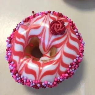 a pink and white donut with sprinkles