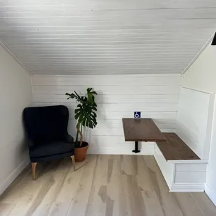 a black chair and a wooden table in a white room