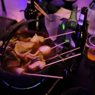 a pot of soup with chopsticks in it