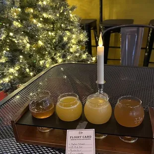 a tray of honey pots on a table in front of a christmas tree