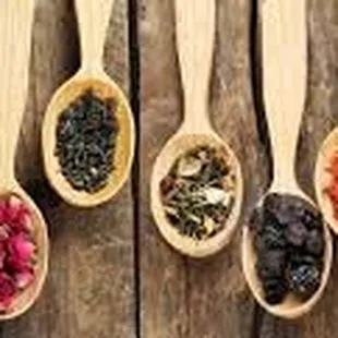 wooden spoons filled with different kinds of beans