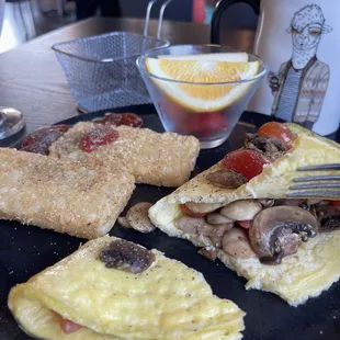 Mushroom tomato omelet. A bit watery - doesn&apos;t feel like real eggs