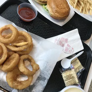 a tray of onion rings and a burger