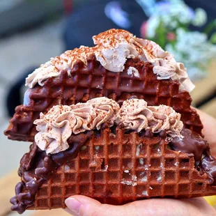 a person holding a chocolate waffle