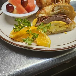 Breakfast sandwich with ham on a croissant.