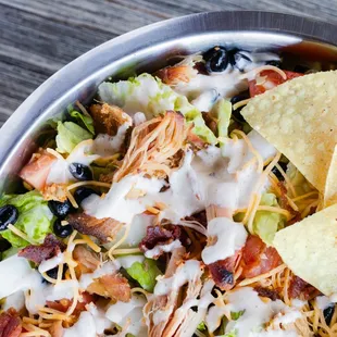 a bowl of chicken salad with tortilla chips