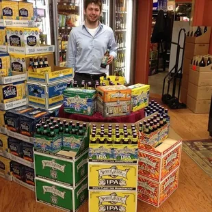 a man standing in front of a stack of beer bottles