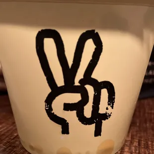 a cup with a hand drawn peace sign on it