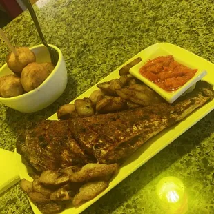 Grilled fish with plantain and puff puff on top