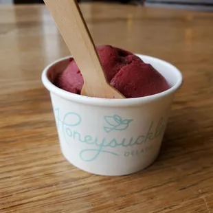 a cup of ice cream with a wooden spoon