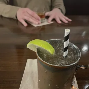 a person sitting at a table with a drink and a straw