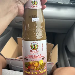 a person holding a bottle of fresh sauce