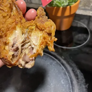 a hand holding a fried chicken sandwich