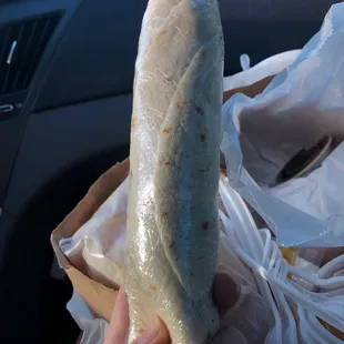 a person holding a large burrito