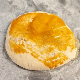 an uncooked doughnut on a piece of wax paper