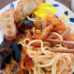 a plate of noodles and meat