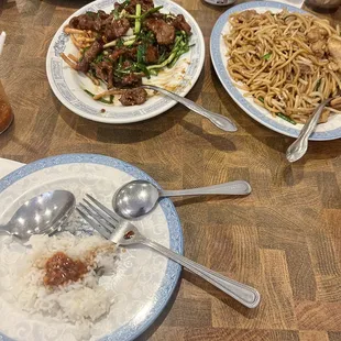 Steamed rice bottom left corner with chili sauce and soy sauce. Chicken lo mein right side. Mongolian beef left side.