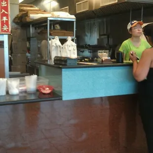 a woman standing at the counter of a fast food restaurant