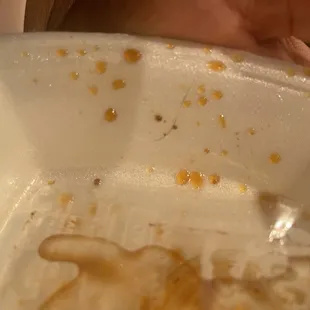 a person's hand holding a plastic container with food in it