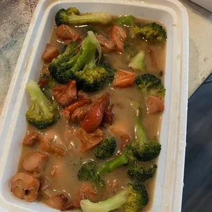 a container of broccoli and meat
