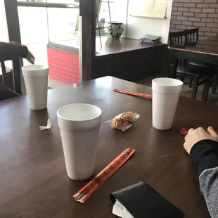 a person holding chopsticks and a cup of coffee