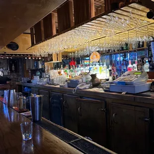 a bar with wine glasses on the bar