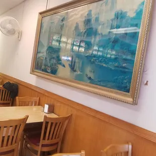 a large painting hanging on the wall of a restaurant
