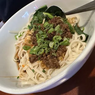 a bowl of noodles with meat and vegetables