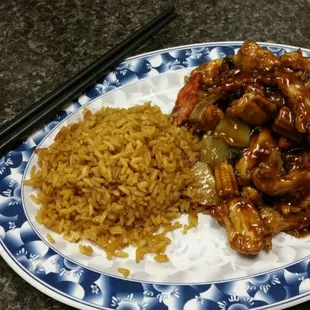 a plate of food with rice and chopsticks