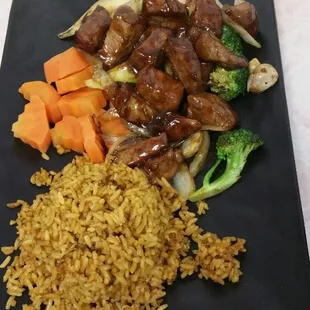 a plate of rice, meat, and vegetables