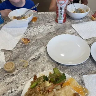 two children sitting at a table with food
