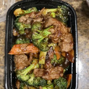 beef, broccoli, and carrots in a black container