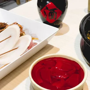 a bowl of red sauce next to a bowl of sliced chicken