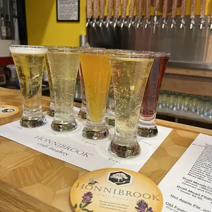 four glasses of beer on a bar