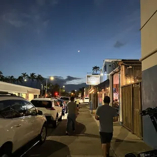 people walking down the sidewalk at night