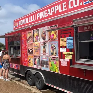 a red food truck parked on the side of the road
