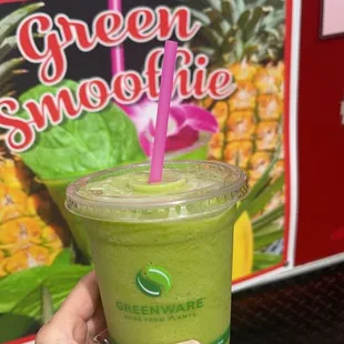 a hand holding a green smoothie