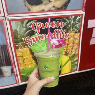 a hand holding a green smoothie