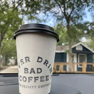 a cup of coffee on the dashboard of a car