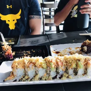 a man taking a picture of the sushi