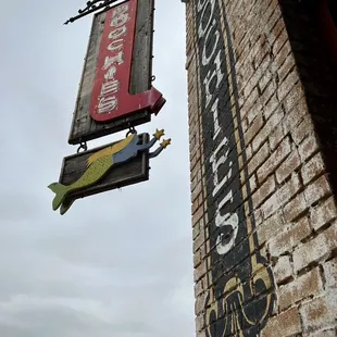 a brick building with a sign hanging from the side