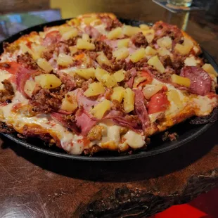 a pizza with pineapples and ham