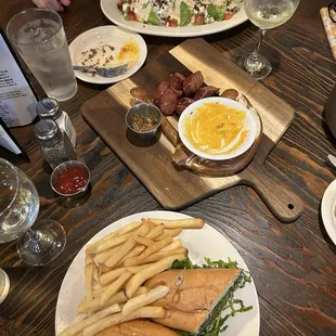 Steak sandwich and wedge salad with pretzel and sausage