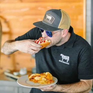 Man enjoying a delicious hot dog with toppings