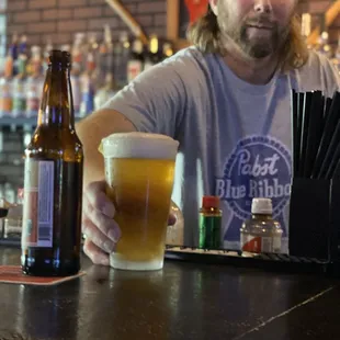 a man sitting at a bar with a beer