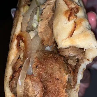 a hand holding a sandwich