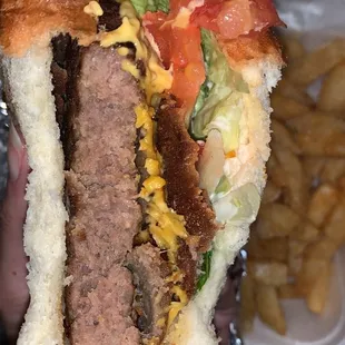 a person holding a hamburger and french fries