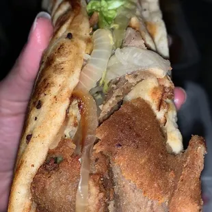 a hand holding a sandwich