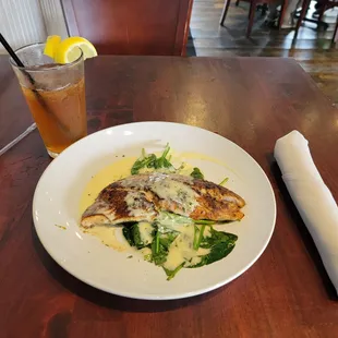 Triple Tail served on spinach with a lemon beurre blanc sauce.