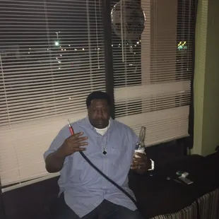 a man sitting on a couch with a hookah